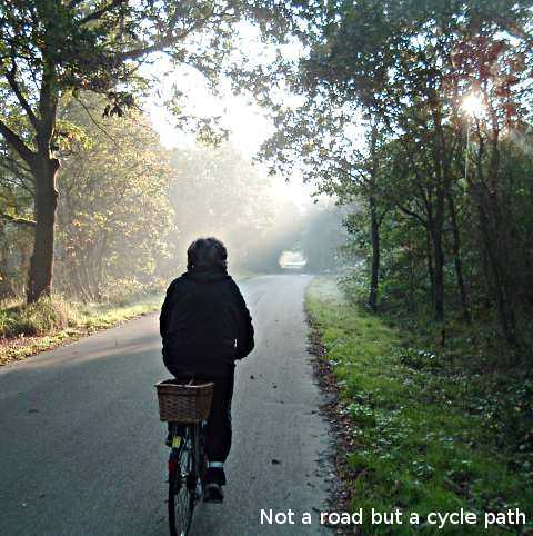 Riding on a rural cycle path towards a short tunnel